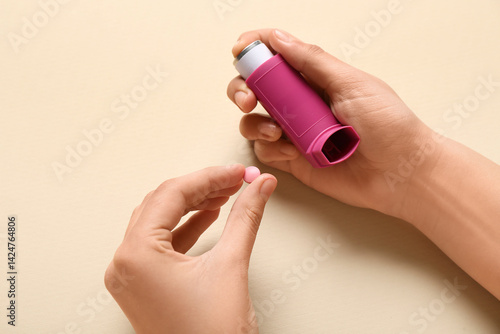Obraz na płótnie Child's hands with asthma inhaler and pill on beige background w salonie