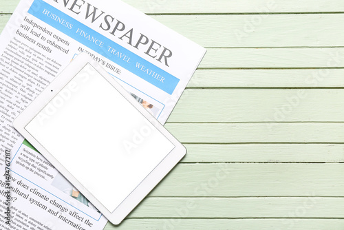 Newspaper with tablet on gr...