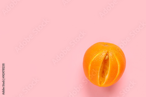 Fresh cut orange on pink ba...