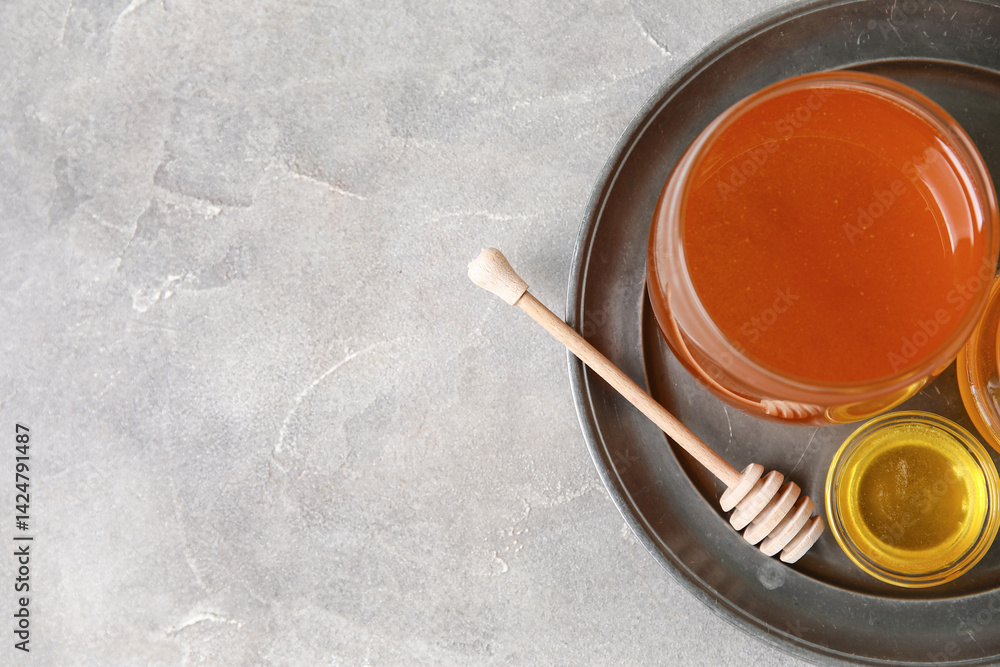 Jar and bowl of sweet honey with dipper on grey grunge background Jar and bowl of sweet honey with dipper on grey grunge background