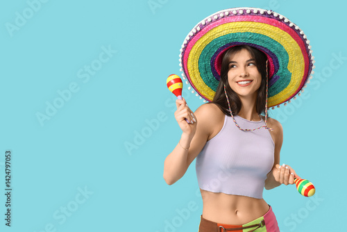 Obraz na płótnie Young woman with colorful sombrero and maracas on blue background. Cinco de Mayo celebration w salonie