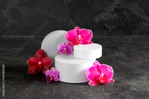Obraz na płótnie Decorative podiums with beautiful orchid flowers on black background w salonie