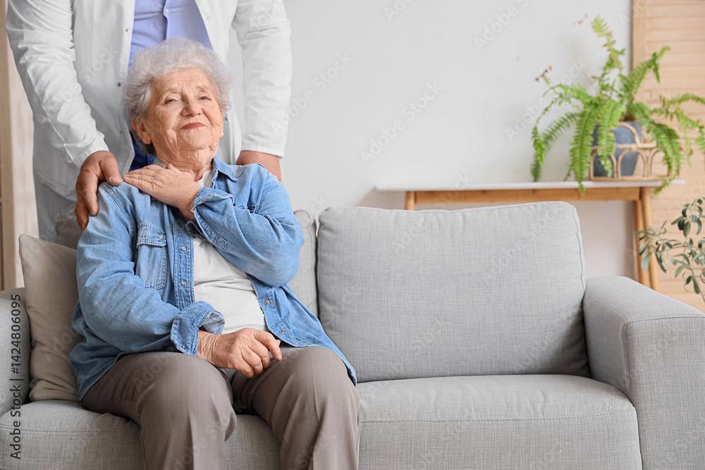 Senior woman with doctor sitting on sofa at home