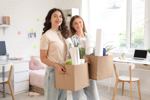Obraz na płótnie Female students with cardboard boxes in dorm room on moving day w salonie