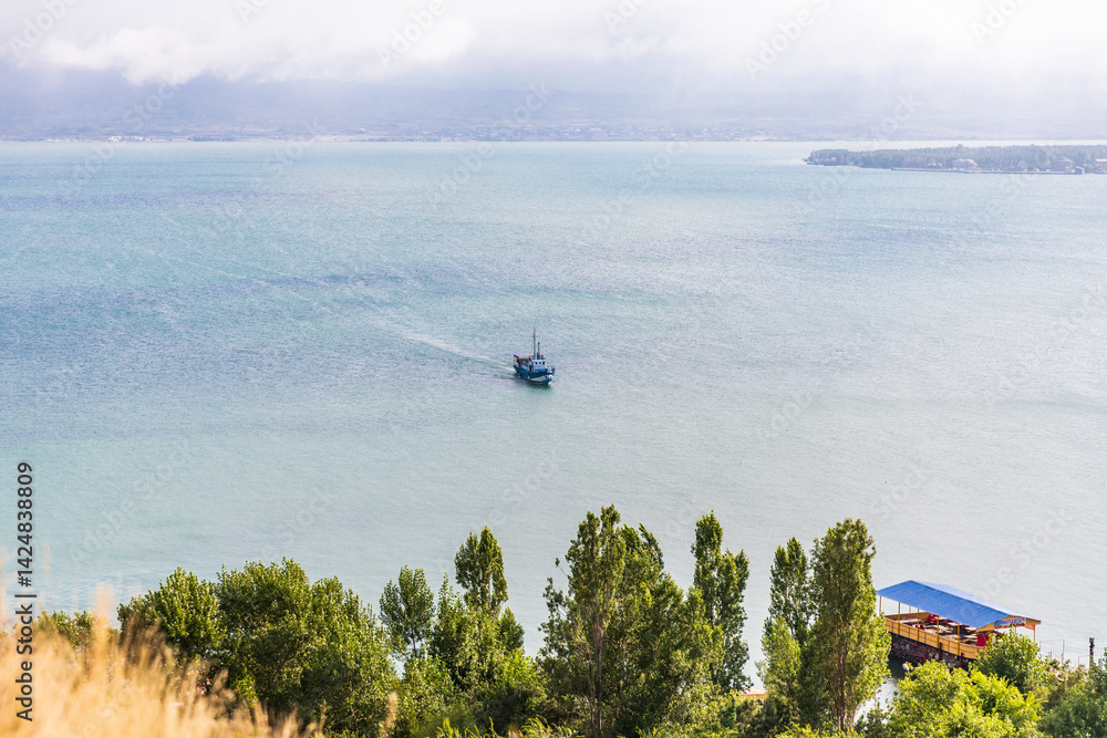 Western Asia, Eurasia, South Caucasus, Republic of Armenia. Sevan. View of tourist boat on Lake Sevan from the Sevanavank Monastery complex.