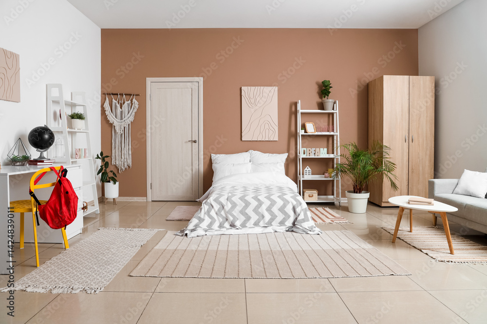 Interior of teenager's room with bed, shelf units and study table