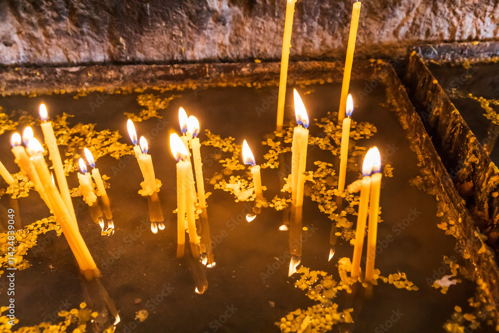 Western Asia, Eurasia, South Caucasus, Republic of Armenia. Sevan. August 15, 2018. Worshippers candles inside of the church of Surp Arakelots at the Sevanavank Monastery complex on Lake Sevan.