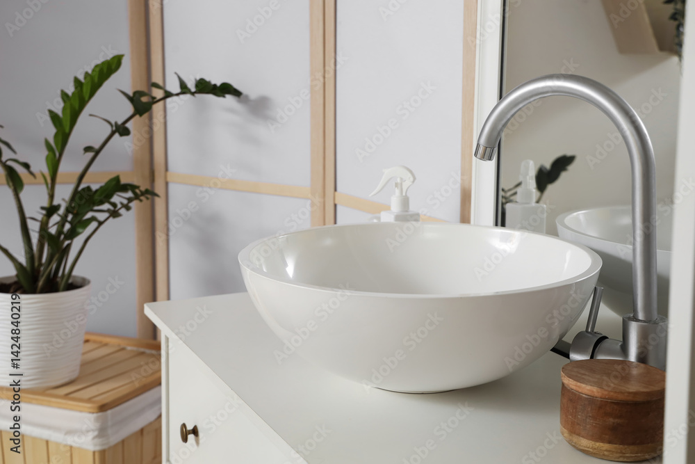 Fototapeta premium Ceramic sink on drawers in light bathroom, closeup