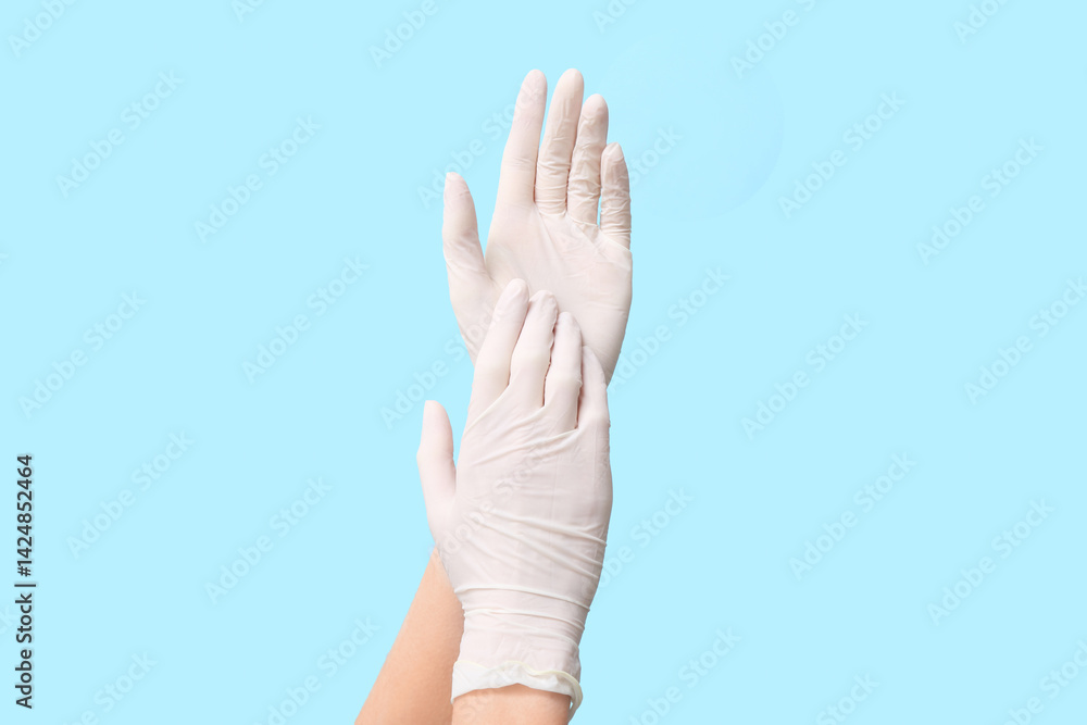 Female hands in medical gloves on blue background Female hands in medical gloves on blue background