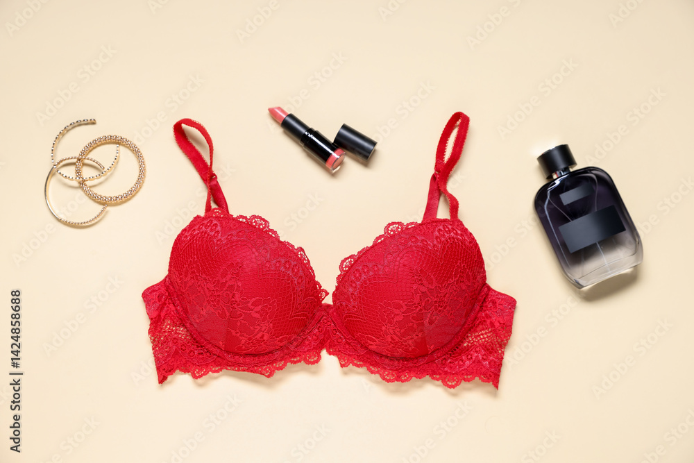 Flat lay composition with red lace bra and cosmetic products on beige background Flat lay composition with red lace bra and cosmetic products on beige background