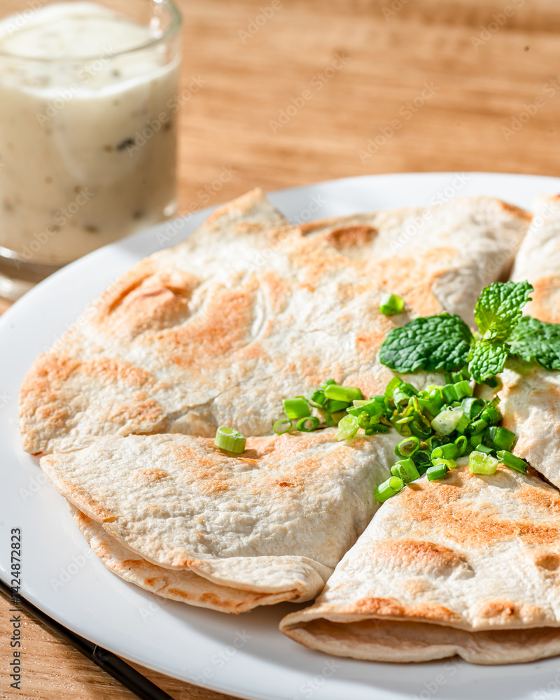A plate of food with a glass of milk on the side. The plate has a variety of food items, including a piece of bread and a piece of meat A plate of food with a glass of milk on the side. The plate has a variety of food items, including a piece of bread and a piece of meat