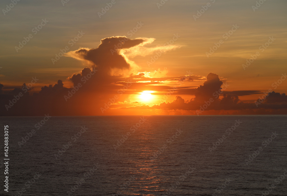 Naklejka premium Fiery Caribbean sunrise through tropical clouds