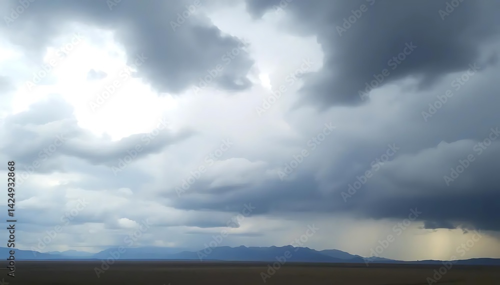 Obraz premium Dramatic rain clouds over a remote landscape with distant mountain range
