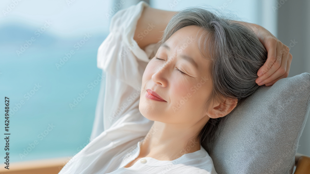 Relaxed woman enjoying serene moments by the window with ocean view in bright, sunny room.