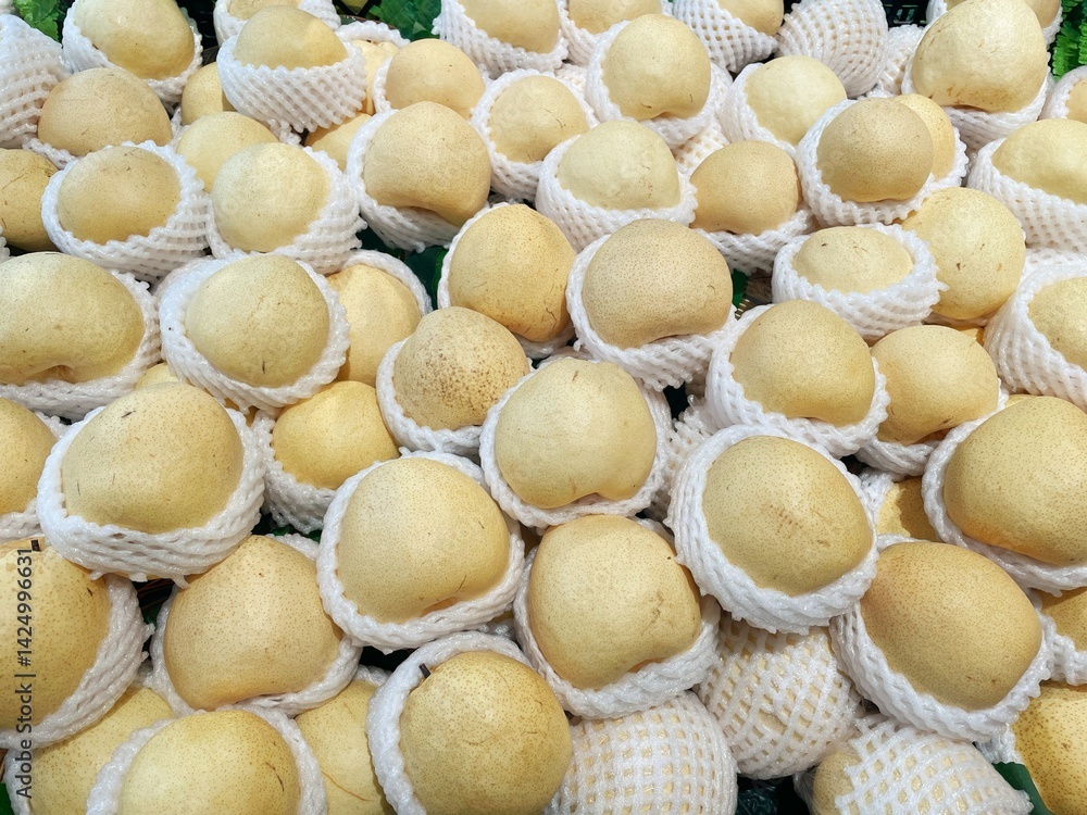 Lots of ripe pears are placed in foam net in a pile as a background texture