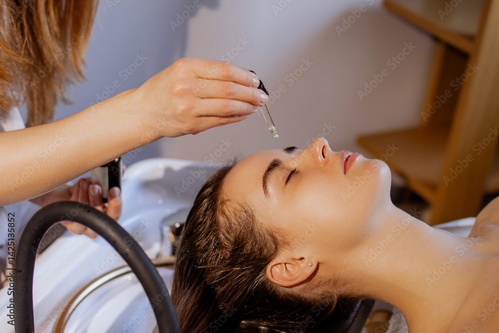 Fototapeta premium Japanese Head Spa Treatment: Applying Essential Oil on Woman's Hair and Scalp During Relaxing Hair Care Session
