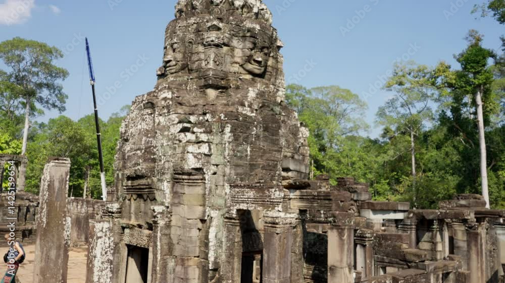 A breathtaking view of stone faces of Angkor Thom temple complex in Cambodia, surrounded by lush greenery. A breathtaking view of stone faces of Angkor Thom temple complex in Cambodia, surrounded by lush greenery.