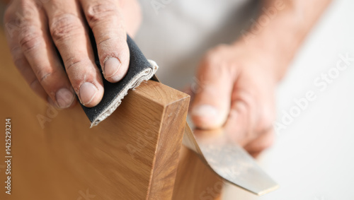 Obraz na płótnie Man is sanding a piece of wood with a piece of sandpaper w salonie