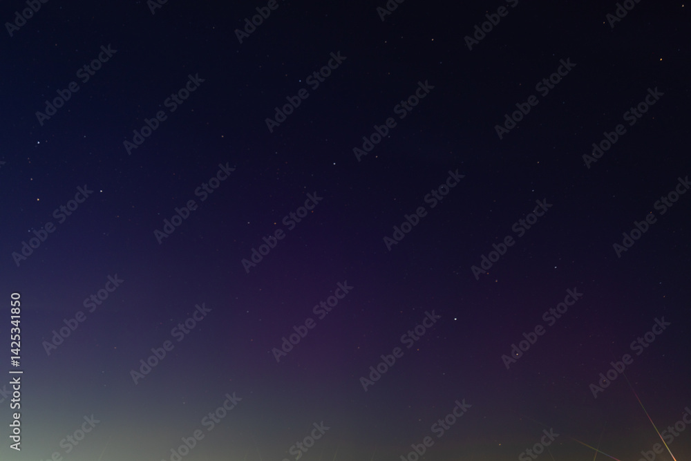 Naklejka premium A clear night sky filled with visible stars gradually fades into a soft horizon glow, creating a tranquil and minimal celestial scene copy space present.
