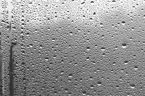 Rain drops on window glass. Natural Pattern of raindrops. Water droplets on a gray background.