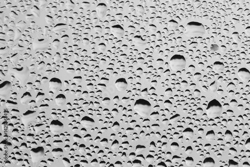 Rain drops on window glass. Natural Pattern of raindrops. Water droplets on a gray background.