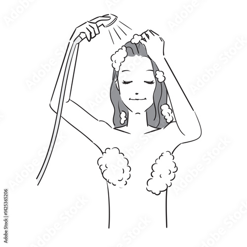 シャンプーした髪をシャワーで洗い流す女性