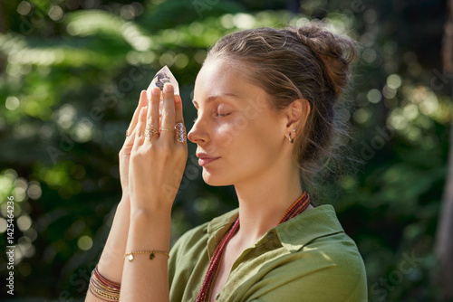 Fotografía Woman meditating with clear quartz flame crystal