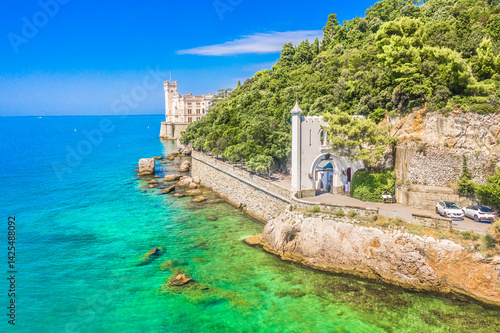 A stunning aerial view of famous landmark near Trieste, Italy, perched on a rocky promontory above the Adriatic Sea, surrounded by turquoise waters, showcasing elegance and coastal charm
