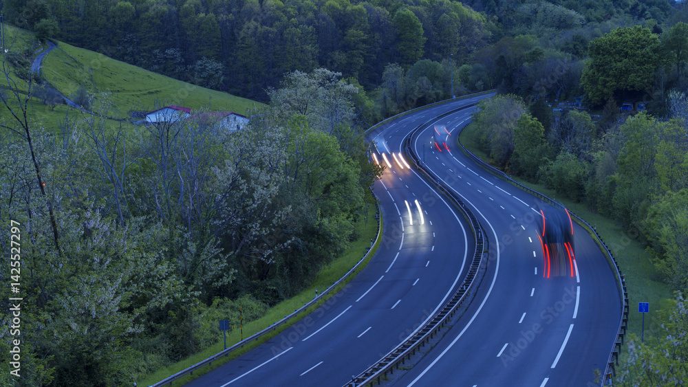 Transport trucks travel along the highway carrying goods to different destinations in the Basque Country.
