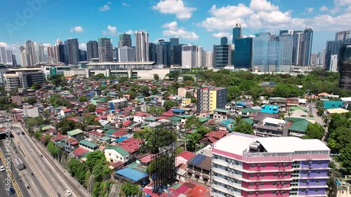 Makati, Metro Manila: Apr 17, 2025 - Aerial of East Rembo homes in Makati with Bonifacio Global City skyscrapers in the background. Example of social divide.