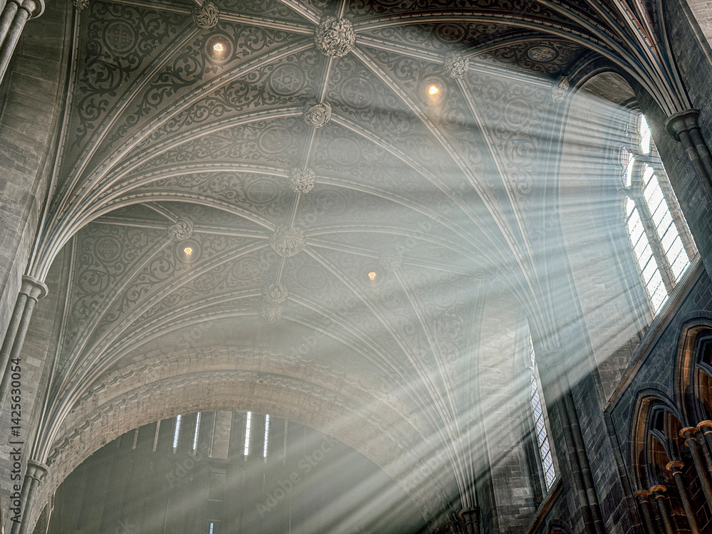 The vaulted ceiling of Hereford Cathedral, Herefordshire, England UK. The sun beams are visible in the incense smoke of the Easter Sunday morning service.