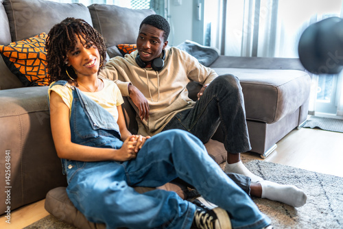 Young couple relaxing and holding hands in living room