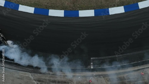 Aerial view car drift on asphalt race track with lot of smoke from burning wheel tires rubber, Drift motorsport car drift race, Professional driver drift car on asphalt race track, Car motion blurred 