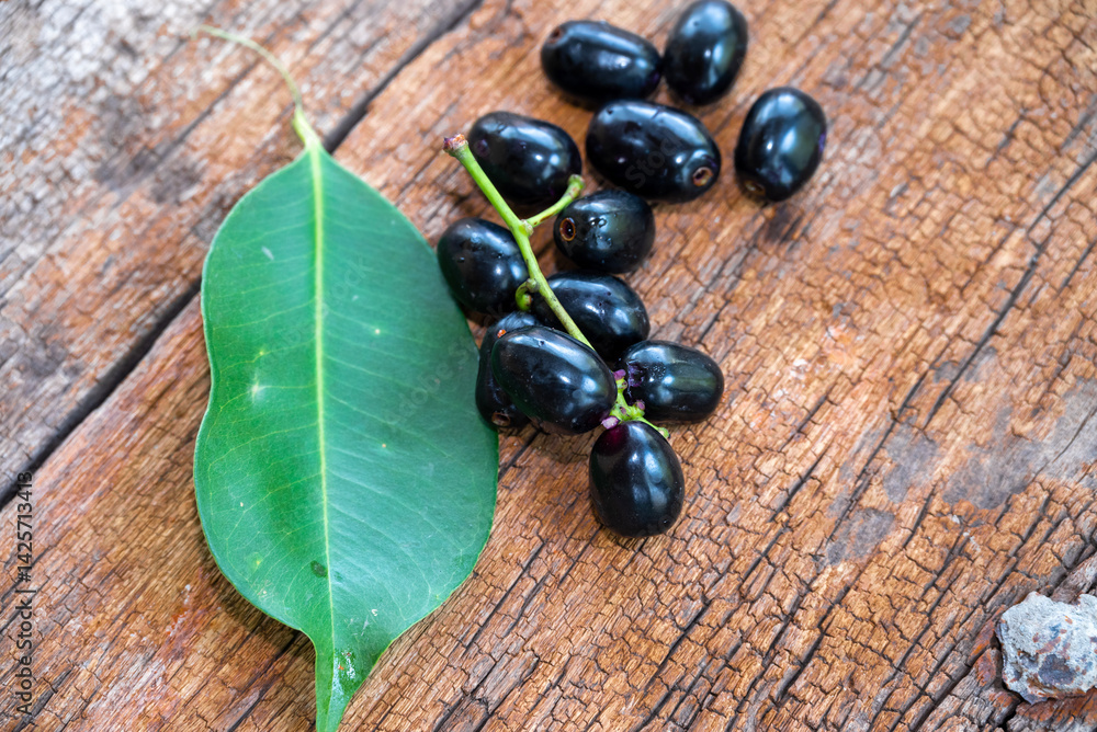 Jambolan plum, Java plum, Jambul( Syzygium cumini (L.) Skeels. on wooden background Jambolan plum, Java plum, Jambul( Syzygium cumini (L.) Skeels. on wooden background