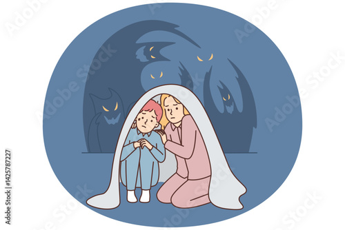 Teenage boy and girl sit wrapped in blanket scared of ghosts after watching scary movie