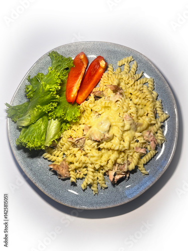 Close up view of macaroni and cheese with vegetables in plate over white background. Top view, flat lay