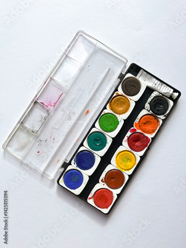 Plastic palette with paints on a white background. With round cells. Top View.