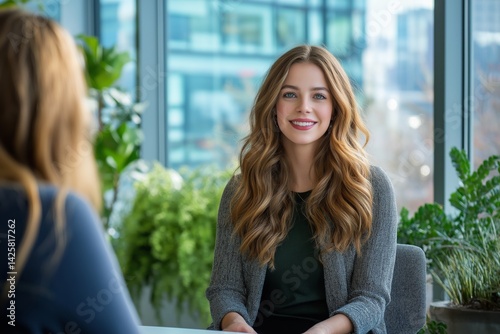 Obraz na płótnie Smiling professional woman sitting across from hiring manager at interview in minimalist office. Concept of career opportunity, professional growth, recruitment process, and human resources. w salonie