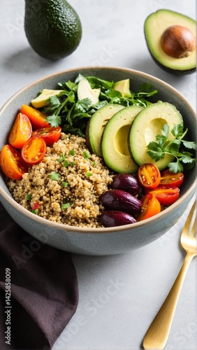 Colorful Quinoa Bowl with Fresh Avocado Slices, Cherry Tomatoes, Greens, and Olives for a Nourishing Meal