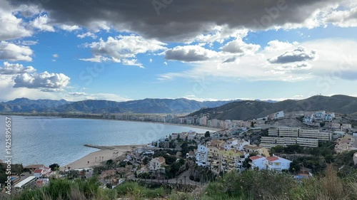 Vertical panoramic view of coastal city, sea, and dramatic sky