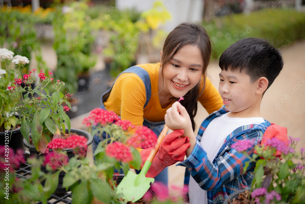 Obraz premium Mother teaching her son how to plant flower. A moment of environmental education and nurturing in a flower garden setting.