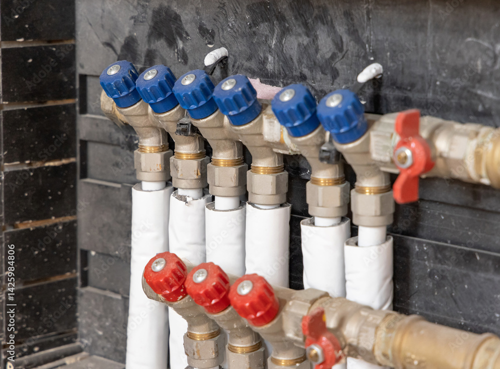 Pipes and valves for hot and cold water in heating and water supply system in boiler room closeup
