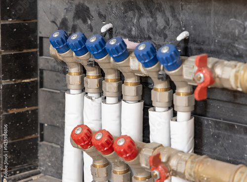 Obraz na płótnie Pipes and valves for hot and cold water in heating and water supply system in boiler room closeup w salonie