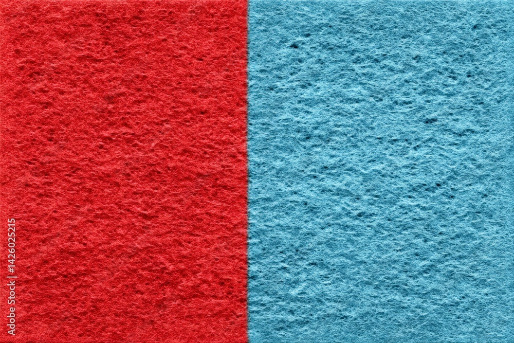 Fototapeta premium Colorful sponge split into red and blue halves displayed on a plain surface for visual contrast and texture exploration