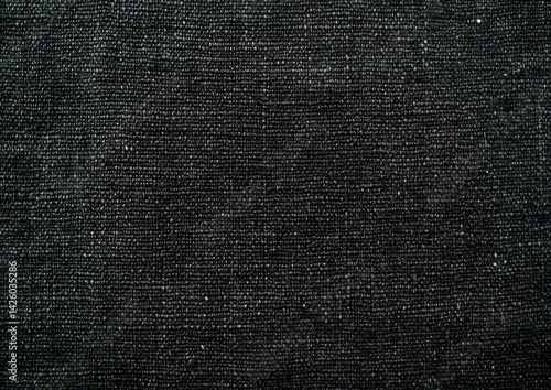 Dark denim fabric texture close-up, showing woven threads. Background is plain. Use textile samples, design inspiration