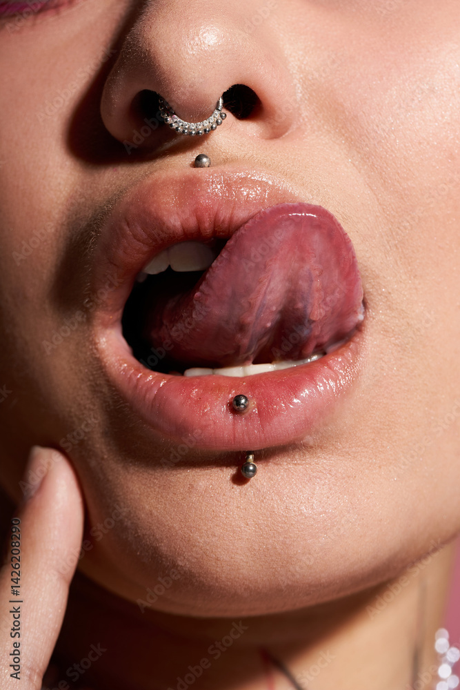 Obraz premium Close up of a stunning young woman with vibrant makeup and stylish piercings.