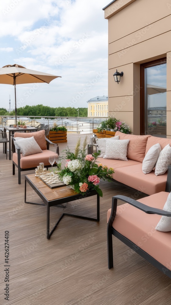 Fototapeta premium Modern rooftop terrace features pallet furniture, a white umbrella, and pink pillows overlooking the vibrant cityscape on a sunny day