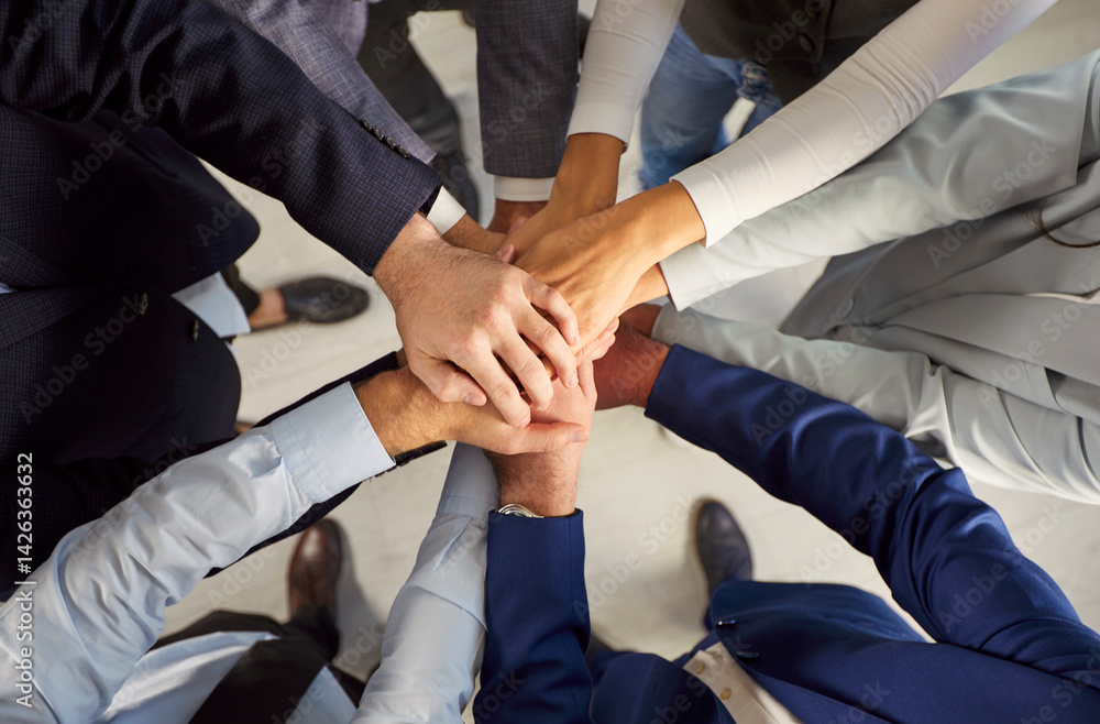 Close up top view photo of business people in formal clothes putting their arms together. Stack of hands of a group of company employees. The concept of unity, partnership and teamwork. Close up top view photo of business people in formal clothes putting their arms together. Stack of hands of a group of company employees. The concept of unity, partnership and teamwork.