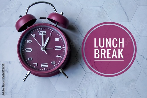 A maroon analog alarm clock with white numbers and hands,  displaying the time as 1 o'clock with text 'LUNCH BREAK' visually emphasizing a designated meal time.