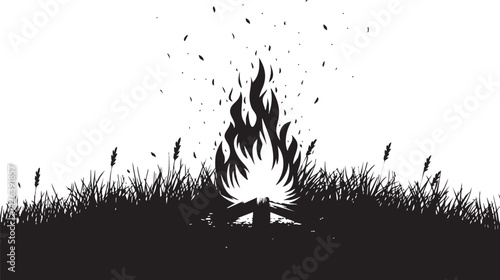 Silhouette of a campfire burning on grassy ground outdoors at night with glowing flames and sparks